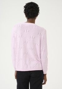 Pull en tricot rose clair avec un motif texturé, manches longues et encolure ronde, avec des bords-côtes aux poignets et à l'ourlet.