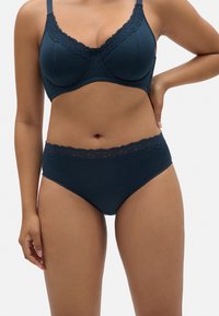 Sujetador azul marino y braguitas a juego hechas de suave tela acanalada. El sujetador tiene un borde de encaje; las braguitas cuentan con un acento de encaje en la cintura.