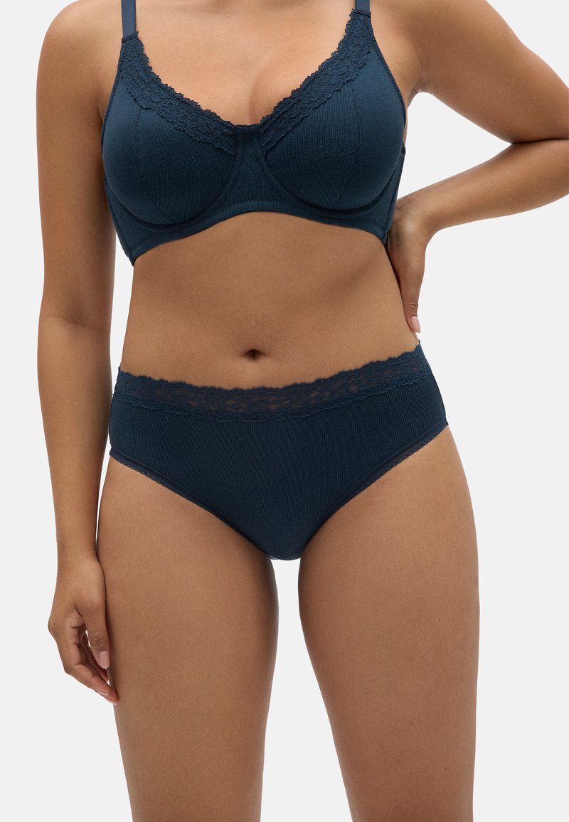 Sujetador azul marino y braguitas a juego hechas de suave tela acanalada. El sujetador tiene un borde de encaje; las braguitas cuentan con un acento de encaje en la cintura.