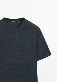 Dunkelgraues Strick-T-Shirt mit kurzen Ärmeln, Rundhalsausschnitt und einem kleinen schwarzen Etikett an der Innenseite des Kragens.