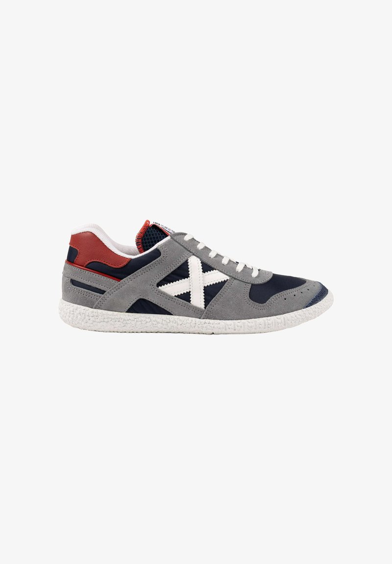 Sneaker basse in suede grigio, mesh navy, lacci bianchi, suola bianca, dettaglio rosso sul tallone e grande "X" bianca sul pannello laterale.
