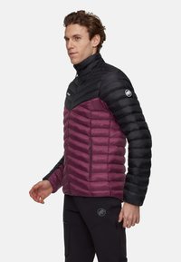 Kurtka ocieplana z czarną górą i śliwkowym dołem z pikowanym wzorem, wysokim kołnierzem oraz kieszeniami na zamek. Logo na ramieniu.