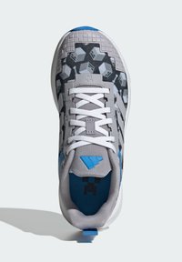 Scarpa sportiva grigia con tomaia strutturata, dettagli blu e lacci bianchi. Presenta un motivo geometrico e un contrafforte del tallone modellato per il supporto.