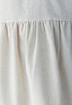Light beige fabric with a textured linen look, featuring gathered pleats along the seam for added volume and detail.
