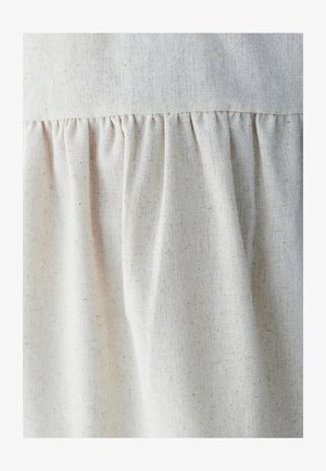 Light beige fabric with a textured linen look, featuring gathered pleats along the seam for added volume and detail.