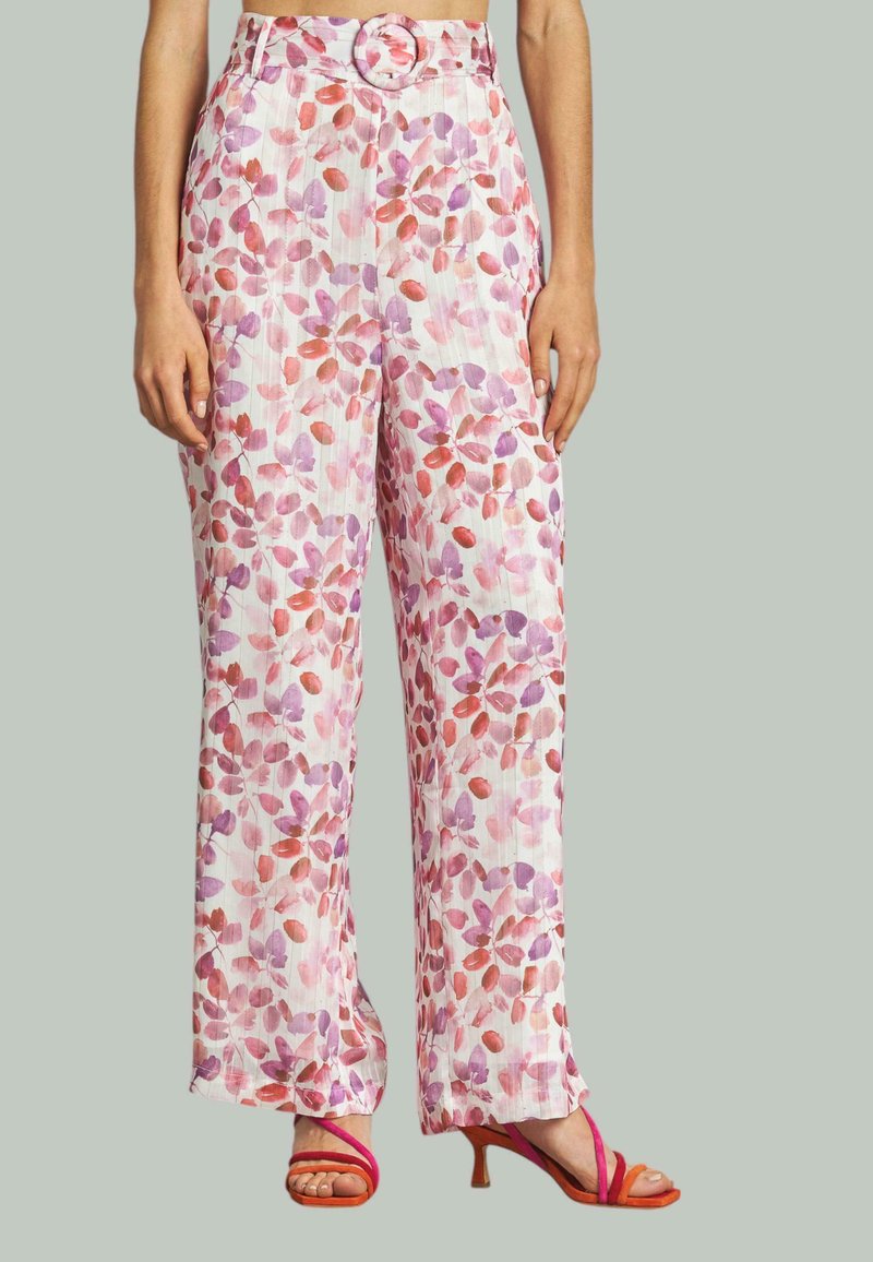 Pantalon à motifs floraux en blanc avec des motifs de feuilles roses et violettes. Présente une taille haute avec une boucle de ceinture ronde et une coupe ample.