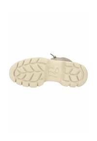 Suola di sneaker beige chiaro con profonde scanalature per aderenza, superficie in gomma testurizzata e logo impresso. Progettata per comfort e durata.