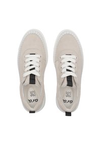 Beige suède sneakers met witte veters en een zwarte accent op de hiel, met een textuurzool en stiksel langs de rand.