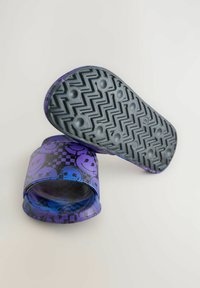 Lila och svarta sandaler med ett leende ansikte och rutmönster, strukturerad överdel och gummisula med en zigzag-profil.