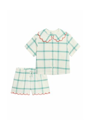 Conjunto de camiseta de manga corta con botones y pantalones cortos con estampado de cuadros verdes y ribete rojo en forma de ondas en el cuello y los bajos de los pantalones.