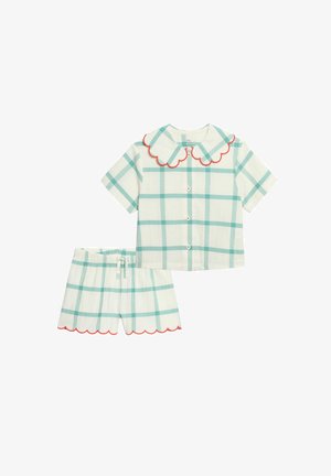 Conjunto de camiseta de manga corta con botones y pantalones cortos con estampado de cuadros verdes y ribete rojo en forma de ondas en el cuello y los bajos de los pantalones.
