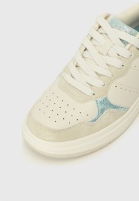 Hvite lær sneakers med lyseblå detaljer, teksturerte semskede elementer, perforert tåboks og flate skolisser. Gummisåle.