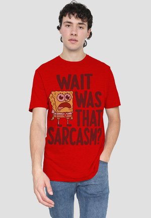 Red cotton T-shirt featuring a large, cartoon-style graphic of a yellow character with wide eyes, and text "WAIT WAS THAT SARCASTIC?" in bold black.
