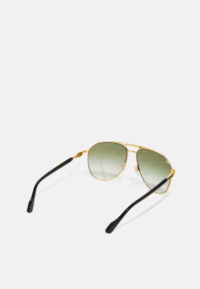 Occhiali da sole aviator in metallo dorato con lenti verdi sfumate; bracci in plastica nera; presenta un motivo sottile sulla lente.
