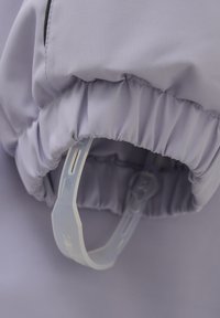 Ljust lila tyg med rynkad söm och fastsydd genomskinlig rem. Texturen är slät med en lätt glans.