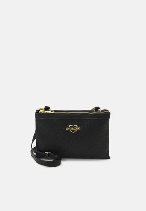 Musta synteettinen olkalaukku, jossa tikattu kuvio, kullanväriset metalliosat, kaksoisvetoketjusuljin ja koristeellinen logokuvake.