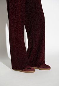 Bordeaux glitterschoenen met wijd uitlopende benen gecombineerd met bordeaux instappers met donkere accenten en verzachte zolen. Glad stoffenafwerking.