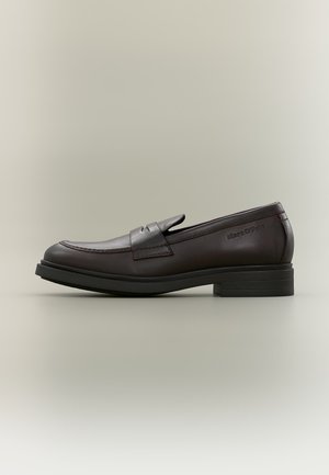 Mørkebrun læderloafer med sort sål og lav hæl, med en møntlomme og præget "Marc O'Polo" logo på siden.