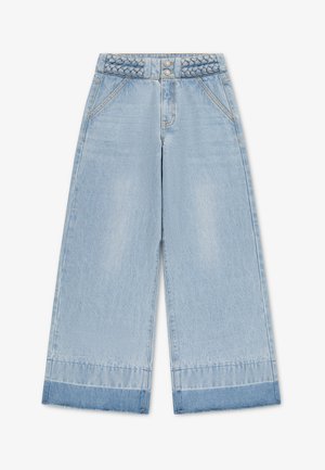 Jean large en denim bleu clair avec ceinture tressée, fermeture à double bouton, poches avant et revers bleu plus foncé sur les ourlets.