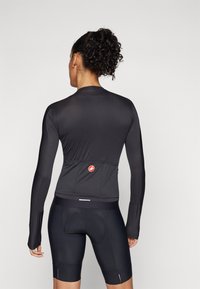 Langärmliges, eng anliegendes Radtrikot aus schwarzem Material. Verfügt über eine Rückentasche und Logodetails. Nahtloses Design mit strukturiertem Stoff und enganliegenden Ärmeln.