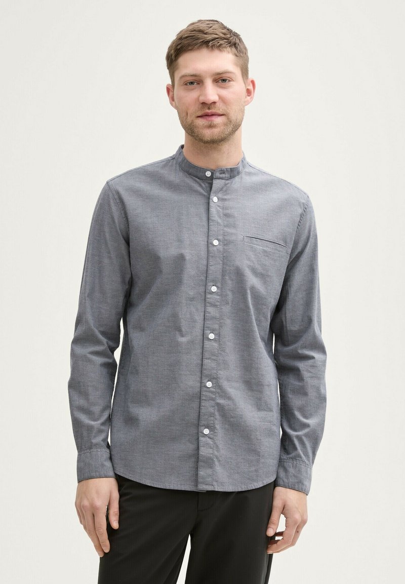 Camicia grigia con colletto alla francese, maniche lunghe e taschino anteriore. Texture liscia, vestibilità standard e bottoni bianchi.