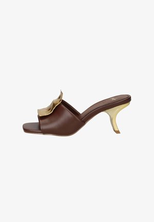 Mule marrone open-toe con tacco basso e curvo dorato e grande dettaglio decorativo dorato sulla fascia superiore.