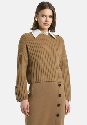 Brauner Rippstrickpullover mit einem weißen Kragenhemd darunter, ausgestattet mit Knopfmanschetten und einem lockeren Schnitt.