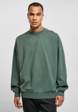 Groene sweatshirt van zacht materiaal, met een geribbelde textuur, ronde halslijn, losse pasvorm, lange mouwen en een elastische onderrand.