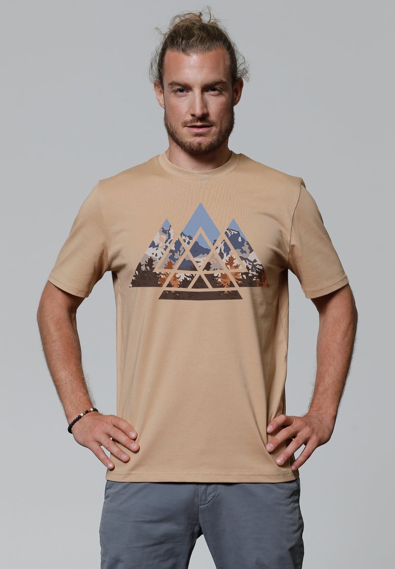 Beige T-Shirt mit kurzen Ärmeln, das ein geometrisches Bergdesign in blauen, braunen und grauen Tönen zeigt. Weicher Stoff, runder Halsausschnitt.