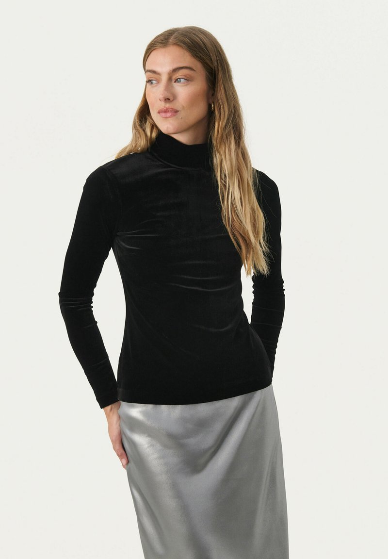 Schwarzer Samt-Turtleneck mit langen Ärmeln, taillierte Passform, glatte Textur, kombiniert mit einem glänzenden silbernen Rock für einen Kontrast.