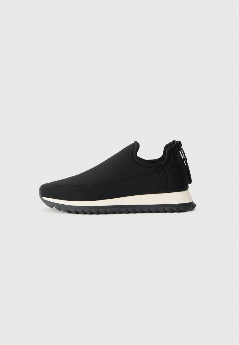 Chaussures noires à enfiler avec un dessus lisse, une semelle intermédiaire blanche et une semelle extérieure en caoutchouc noir texturé. Présente un détail de fermeture éclair au niveau du talon.