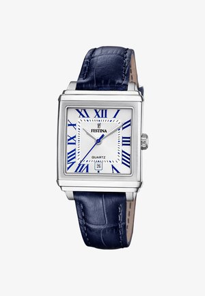 Montre carrée à quartz avec boîtier en acier inoxydable argenté, cadran blanc, chiffres romains bleus, et bracelet en cuir bleu marine texturé. Affichage de la date à 6 heures.