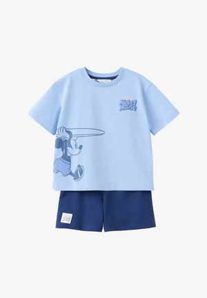 Hellblaues T-Shirt mit kurzen Ärmeln und Mickey Mouse Grafik, der ein Surfbrett hält, kombiniert mit dunkelblauen Shorts mit kleinem Mickey Mouse Label.