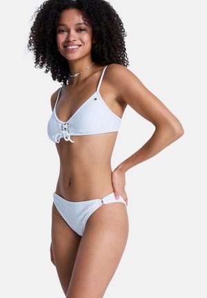 Ensemble bikini blanc composé d'un haut triangle texturé avec une fermeture à nouer devant et un bas taille basse assorti avec des accents ronds sur les côtés.