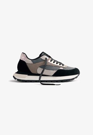 Sneakers sportivi con punta in suede nero testurizzato, parte superiore in mesh grigio e finiture metalliche. Lacci neri e suola bianca spessa con battistrada nero.