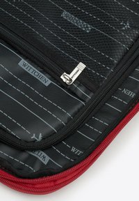 Zwarte nylon laptophoes met ritssluiting, rode accenten en een interieur met een geometrisch patroon en de merknaam "WITTCHEN."