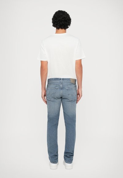 Ανοιχτό μπλε τζιν παντελόνι με ίσια εφαρμογή, που διαθέτει σχέδιο πίσω τσέπης, δερμάτινη ετικέτα στη ζώνη, και κλασικό κλείσιμο με κουμπί.