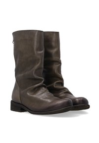 Brązowe skórzane botki za kostkę o luźnym fasonie, okrągłych noskach i niskim, zintegrowanym obcasie. Brak widocznych detali metalowych. Gładka faktura.