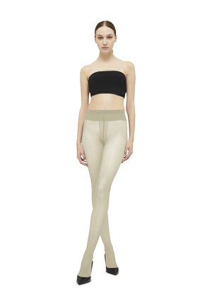 Beige strømpebukser med en glat tekstur og en høj talje, parret med en sort bandeau-top. Modellen står i sorte højhælede sko.