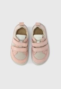Chaussures pour enfants roses et beiges en cuir suédé et mesh, avec deux bandes Velcro, un col rembourré et une semelle en caoutchouc texturée.