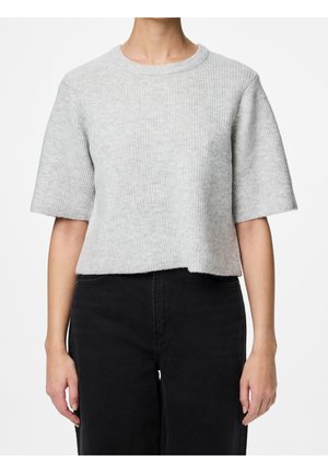 Torso met een lichtgrijze geribbelde korte mouwen gebreide trui, gecombineerd met een zwarte broek met hoge taille, tegen een witte achtergrond.