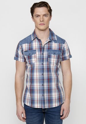 Camicia a maniche corte a quadri nei colori blu, rosso e bianco. Dettagli in denim sulle spalle e sulle tasche del petto; chiusura anteriore con bottoni.