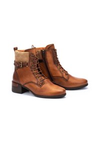 Botas de cuero marrón hasta el tobillo con cierre de cordones en la parte delantera, cremallera, cuello de pana y un tacón bajo cuadrado.