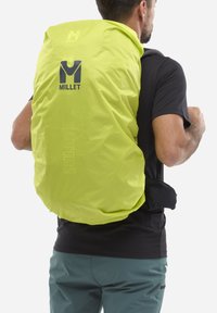 Housse de sac à dos étanche jaune de Millet, fabriquée en matériau léger. Présente un grand logo et un haut resserré pour un ajustement sécurisé.