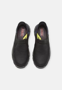 Black slip-on shoes with a smooth leather-like upper, cushioned insole, and rubber outsole. Blue and yellow accents on the design.