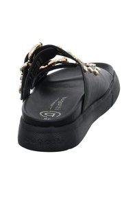 Sandale noire avec des brides synthétiques lisses ornées de détails dorés et une semelle texturée antidérapante. Plateforme légèrement surélevée pour le confort.