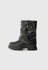 Bottes noires mi-mollet en matériau synthétique brillant avec un design plissé, dotées d'un détail argenté rond et d'une semelle extérieure en caoutchouc épaisse.