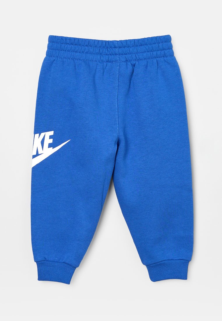 Pantaloni della tuta blu con vita elastica. Presentano un logo Nike bianco e un design a gamba affusolata. Realizzati in un tessuto morbido e textured.