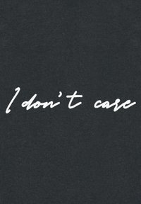 Tessuto nero con superficie testurizzata che presenta testo bianco in corsivo che recita "Non mi interessa." Design semplice, senza grafica aggiuntiva.
