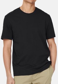 Schwarzes Baumwoll-T-Shirt mit Rundhalsausschnitt, kurzen Ärmeln, lässiger Passform, glatter Textur und ohne sichtbare Muster oder Akzente.